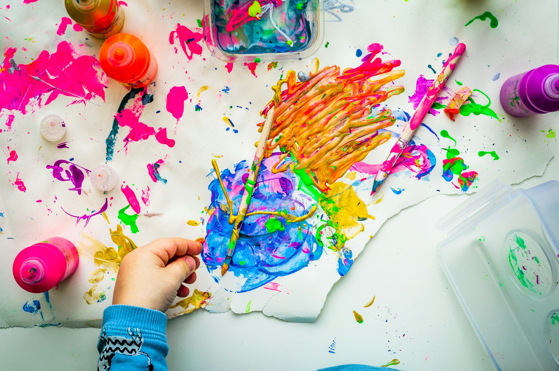 Manos de niños creando una pintura